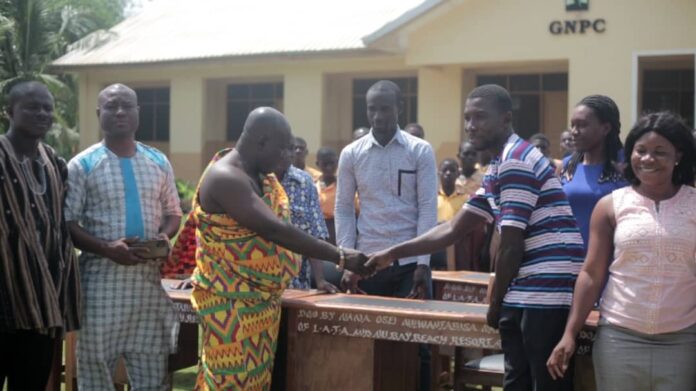 HRM Awulae Attibrukusu III in cloth presenting the items to the headmaster of the school.