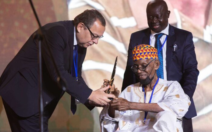 Joe Lartey received his award from AIPS Secretary General Jura Ozmec. (Photo by Carlo Pozzoni/AIPS Media)